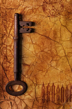 The old key on the textured paperの写真素材
