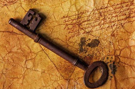 The old key on the textured paperの写真素材