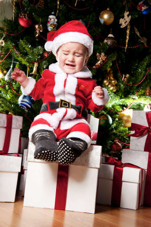 Crying little boy with gift boxes