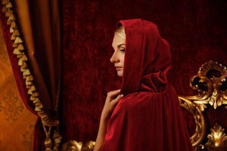 Woman in red hood in luxury interiorの写真素材