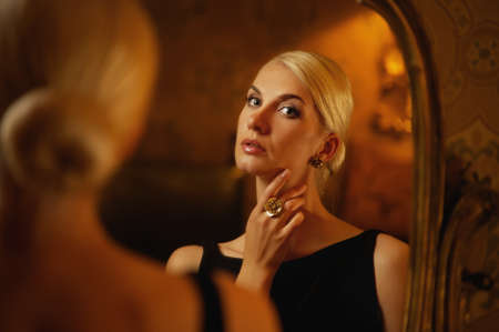 Beautiful woman reflected in vintage mirrorの写真素材