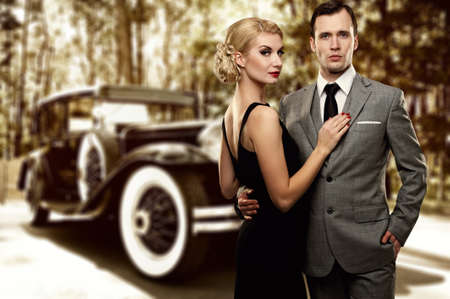 Retro couple against old car.の写真素材