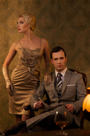 Retro couple sitting behind table.の写真素材