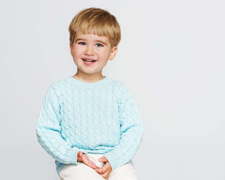 Smiling baby boy in blue pulloverの写真素材