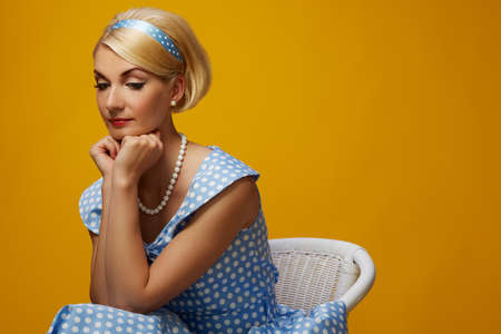 Pensive woman in a blue dress sitting