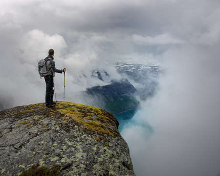 Man with hiking equipment standing on rock's edgeの写真素材