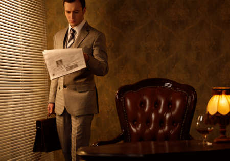 Retro businessman reading newspaperの写真素材