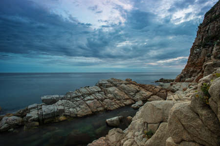 Gloomy sky over rocky shoreの写真素材