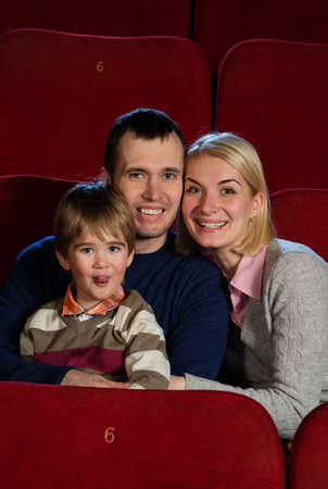 Young man and woman with their child in a cinemaの写真素材