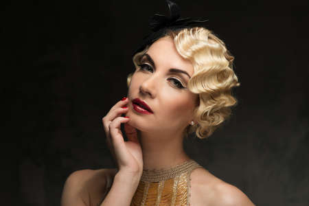Elegant blond retro woman  wearing little hat with beautiful hairdo and red lipstick