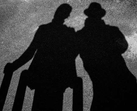 Two strangers shadows on pavementの写真素材