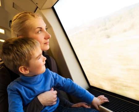 Young mother with her little son traveling on trainの写真素材