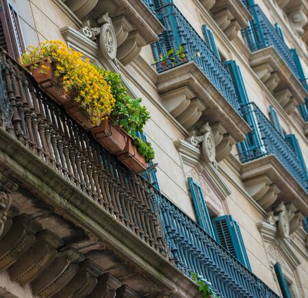 Building facade with beautiful balcony full of flowersの写真素材