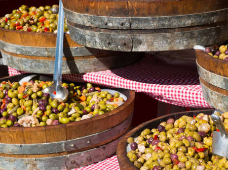 Different colourful olives in barrels
