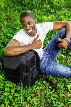 Young smiling african american man with rucksack in a park