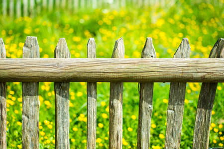 Wooden fence with meadow behind it の写真素材