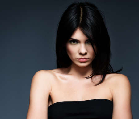 Young beautiful strict brunette woman isolated on grey background の写真素材