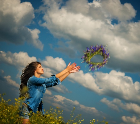 Beautiful young brunette in shorts and chaplet throwing chaplet in a raps fieldの写真素材
