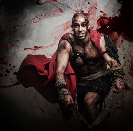 Wounded gladiator attacking with two swordsの写真素材