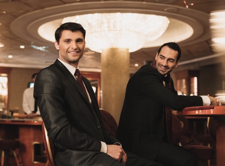 Two young men in suits behind table in a casino