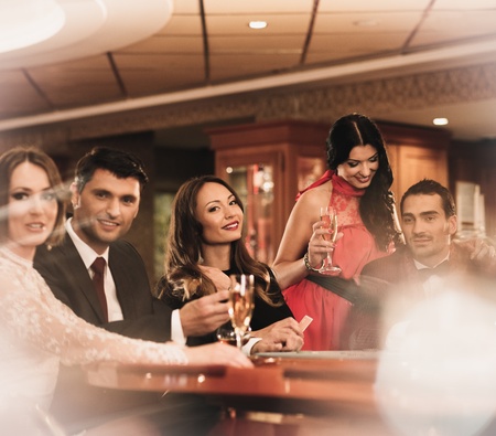 Group of young people playing poker in a casinoの写真素材