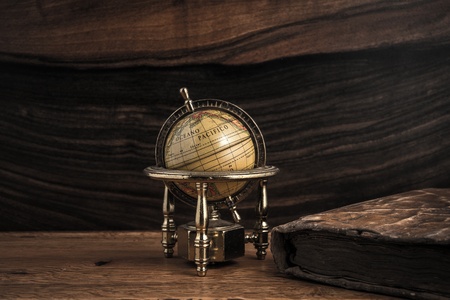 Vintage book and little globe on a wooden background の写真素材