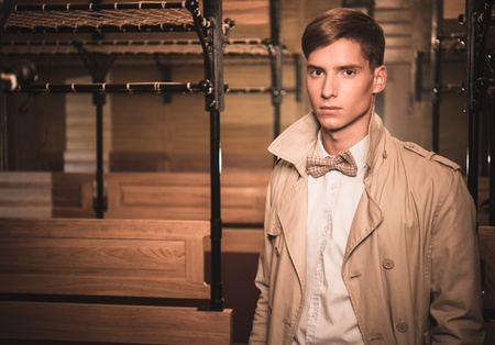 Handsome young man in coat inside vintage train coach の写真素材
