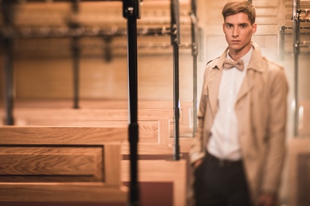 Handsome young man in coat inside vintage train coach の写真素材
