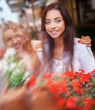 Two beautiful girls among flowers outdoors in a cityの写真素材