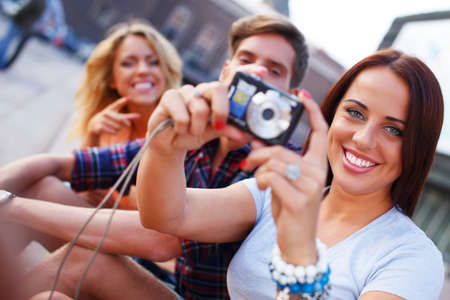 Group of friends with photo camera outdoorsの写真素材