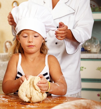 Cook helping her little protege cooking homemade pastryの写真素材