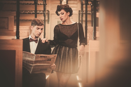 Beautiful vintage style couple reading newspaper  inside retro train coach の写真素材