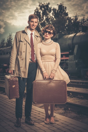 Beautiful vintage style couple with suitcases on  train station platformの写真素材