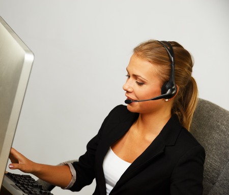 Beautiful help desk office support woman with headsetの写真素材