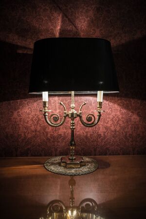 Vintage style lamp on a polished wooden table の写真素材