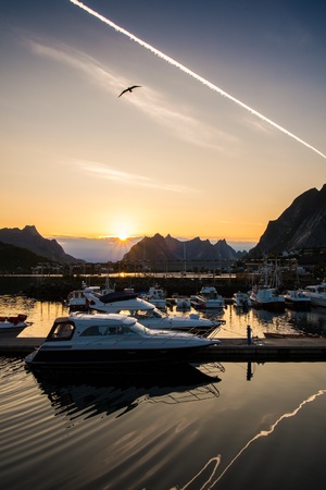 Yachts and boats near moorage at sunset in Reine village, Norwayの写真素材
