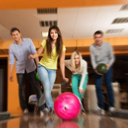 Group of four young smiling people playing bowling の写真素材