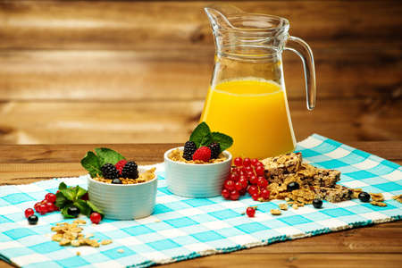 Healthy breakfast with fresh orange juice on tablecloth in wooden rural interior 