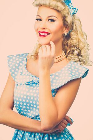 Sexy blond pin up style young woman in blue dress