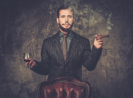 Handsome well-dressed with glass of beverage and cigar