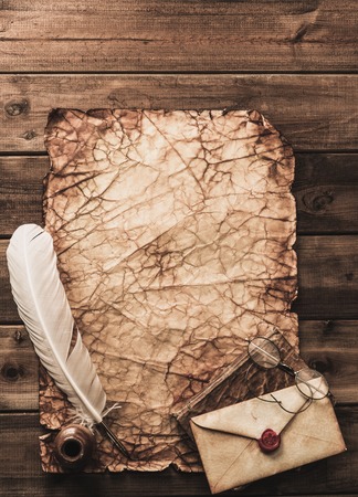 Writing accessories on a vintage paper on wooden background の写真素材