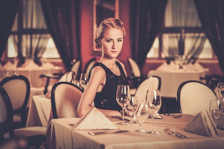 Young beautiful girl alone in a luxury restaurantの写真素材