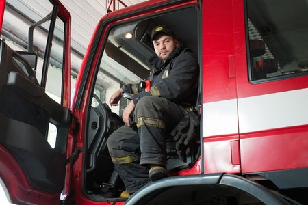 Fireman behind steering wheel of a firefighting truck 