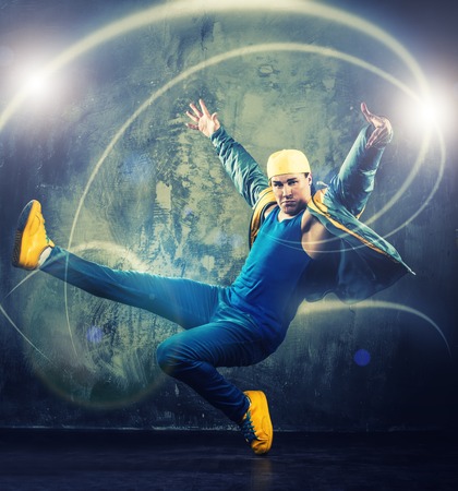 Stylish man dancer showing break-dancing moves with magic beams around him の写真素材