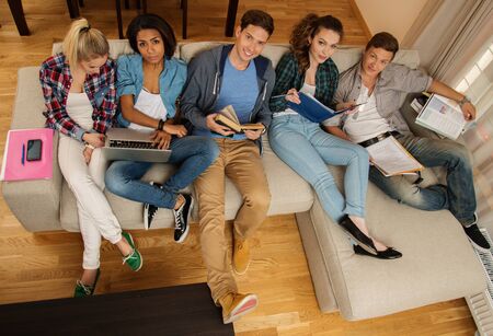 Group of multi ethnic young students preparing for exams in home interior の写真素材