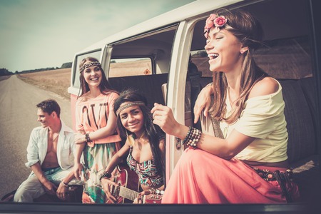 Multi-ethnic hippie friends with guitar on a road tripの写真素材