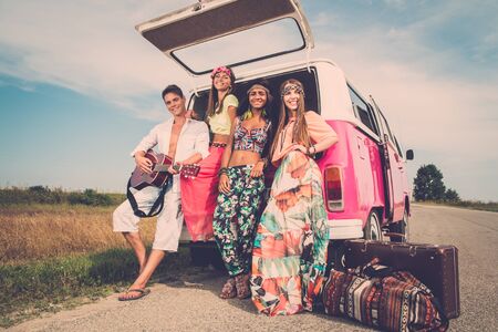 Multi-ethnic hippie friends with guitar on a road tripの写真素材