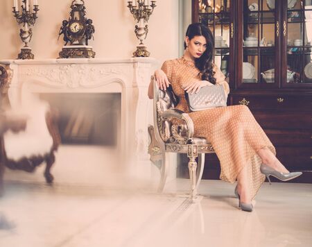 Woman near fireplace in luxury house interior の写真素材