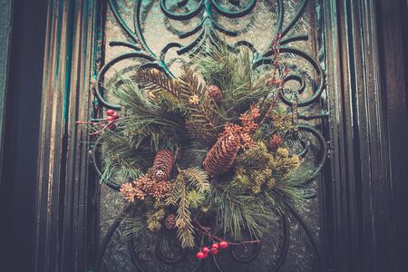 Christmas wreath with cones hanging on a doorの写真素材