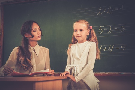 Little schoolgirl answering near blackboard in schoolの写真素材